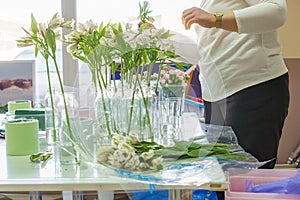 A florist is preparing a workplace for a master class for children on assembling bouquets of flowers. education in the school of