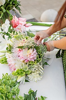 Florist\'s Hands Finishing a Floral Bouquet. Florist at work. Workplace. Small business. Background
