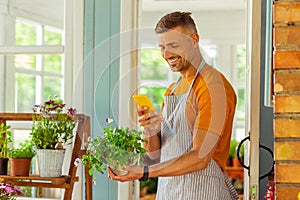 Florist taking a picture of a plant outside.