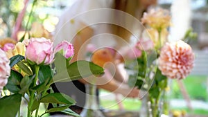 Florist woman finished to arranging flowers in glass outdoors decoring wedding slow motion