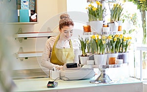 Florist woman at flower shop cashbox on counter