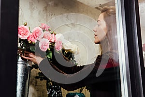 Florist woman on the work on flowers background.