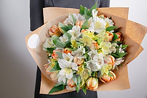 Florist at work. Alstroemeria bouquet of white and orange tulips. Vintage floristic background, colorful roses, antique