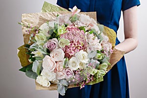 Florist at work. Make hydrangea rich bouquet. Vintage floristic background, colorful roses, antique scissors and a rope