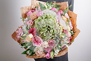 Florist at work. Make hydrangea rich bouquet. Vintage floristic background, colorful roses, antique scissors and a rope