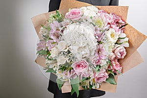 Florist at work. Make hydrangea rich bouquet. Vintage floristic background, colorful roses, antique scissors and a rope