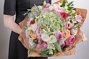 Florist at work. Make hydrangea rich bouquet. Vintage floristic background, colorful roses, antique scissors and a rope