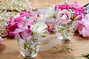 Florist workplace: incomplete tiny bouquets in glass vases