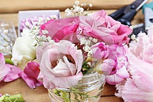 Florist workplace: incomplete tiny bouquets in glass vases