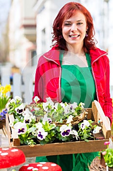 Floristin mit Pflanzen Lieferung vor Laden