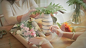 Florists are creating beautiful bouquet with different flowers at their floral shop. Small business concept