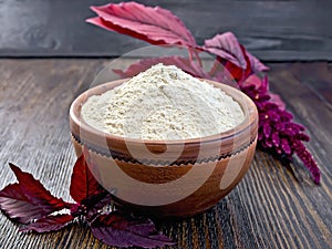 Flour amaranth in clay bowl on dark board