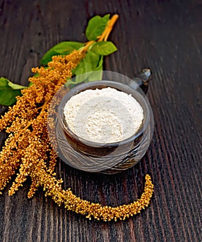 Flour amaranth in clay cup on board