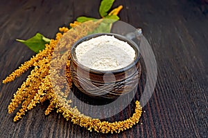 Flour amaranth in clay cup on dark board