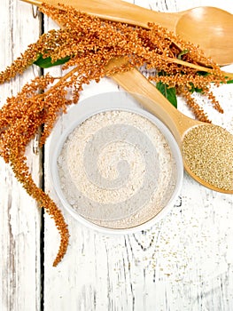 Flour amaranth in white bowl with spoon on board top