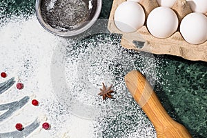 Flour, berries and anise star spices as a decoration and rolling pin, eggs, strainer