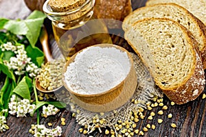 Flour buckwheat green in bowl with bread on wooden board