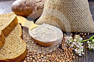 Flour buckwheat in spoon with cereals and bread on board photo