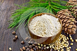 Flour cedar in wooden bowl with nuts on board