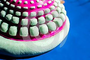 Flour dough to make pasta with square shapes, using a pink strainer