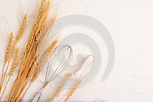 Flour and ears of wheat, barley, cooking, bread, and cookies are arranged on the table in a rustic kitchen, top view