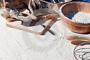 Flour and ears of wheat, barley, cooking, bread, and cookies were arranged on the wooden table background in a rustic kitchen. Top