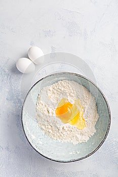 Flour with egg in bowl - cooking and baking ingredients