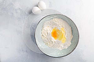 Flour with egg in bowl - cooking and baking ingredients