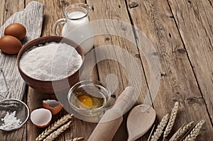 Flour, egg, milk on wooden table rustic kitchen