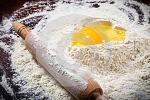 Flour, egg and rolling pin on table