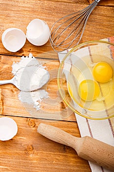 Flour, eggs and salt on the wooden table