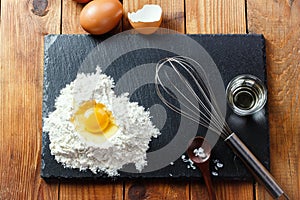 Flour with eggs on wooden table