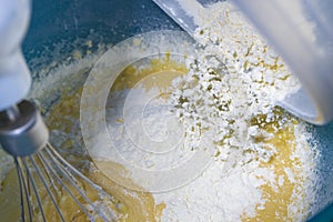 Flour falling onto beaten egg to make a dessert. photo