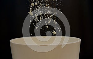 Flour falling on a white bolws photo
