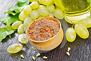 Flour grape seed in bowl on dark wooden board