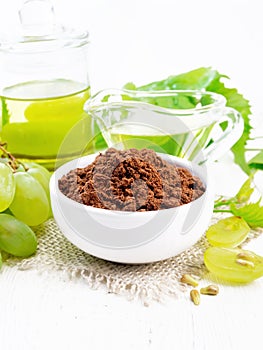 Flour grape seed in bowl on white wooden board