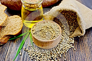 Flour hemp in bowl with bread and oil on board