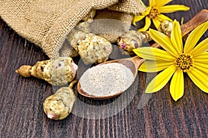 Flour of Jerusalem artichoke in spoon with flower on board