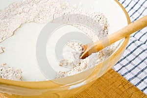 Flour, milk and a spoon in a bowl