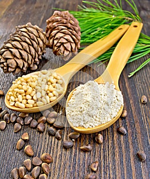 Flour and nuts cedar in spoon on board