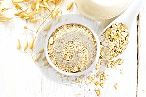 Flour oat in bowl with milk on light board top