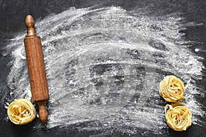 Flour and rolling pin on the table. The process of cooking tagliatelle pasta on the kitchen table