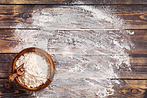 Flour scattered in the form of a circle, rolling pin and white linen napkin on an old wooden background. Place for text.