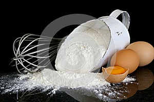 Flour Scoop Eggs and Whisk on Black Marble photo
