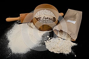 Flour sieved for homemade pastries. Accessories in home kitchen on a dark table