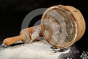 Flour sieved for homemade pastries. Accessories in home kitchen on a dark table
