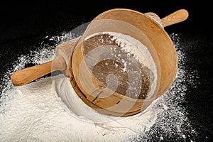 Flour sieved for homemade pastries. Accessories in home kitchen on a dark table