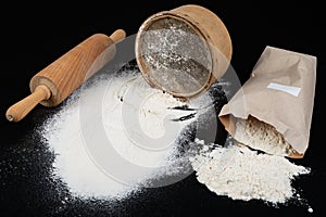 Flour sieved for homemade pastries. Accessories in home kitchen on a dark table