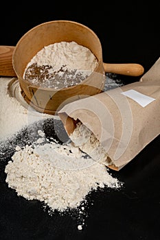 Flour sieved for homemade pastries. Accessories in home kitchen on a dark table