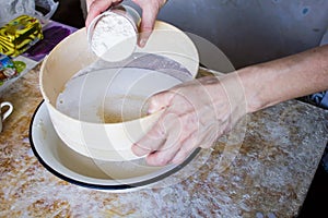 Flour is sifted through a wooden sieve